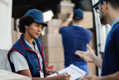 two-deliverers-communicating-going-through-paperwork-while-their-colleagues-is-loading-packages-van-focus-is-african-american-woman_637285-1256